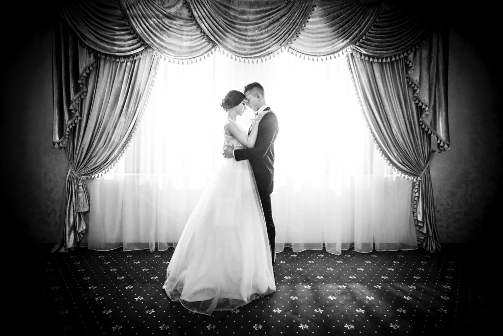 Photography of Couple Facing in Front Curtain